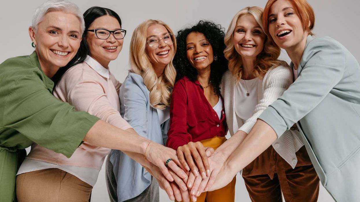 Multi-ethnic group of happy mature women holding hands