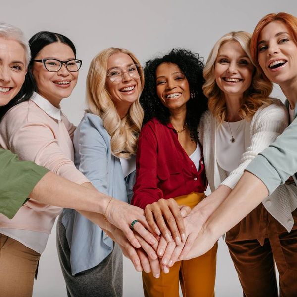 Multi-ethnic group of happy mature women holding hands