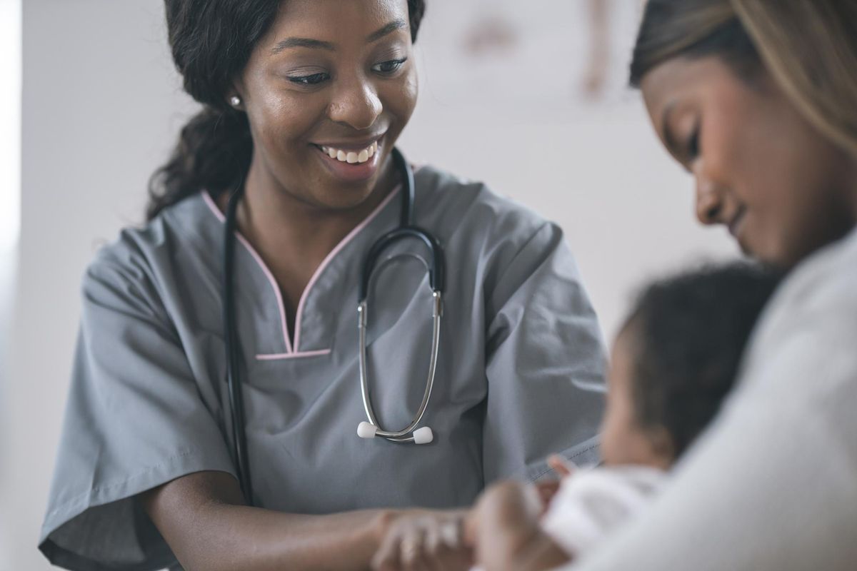 Nurse checking baby in wellness medical exam