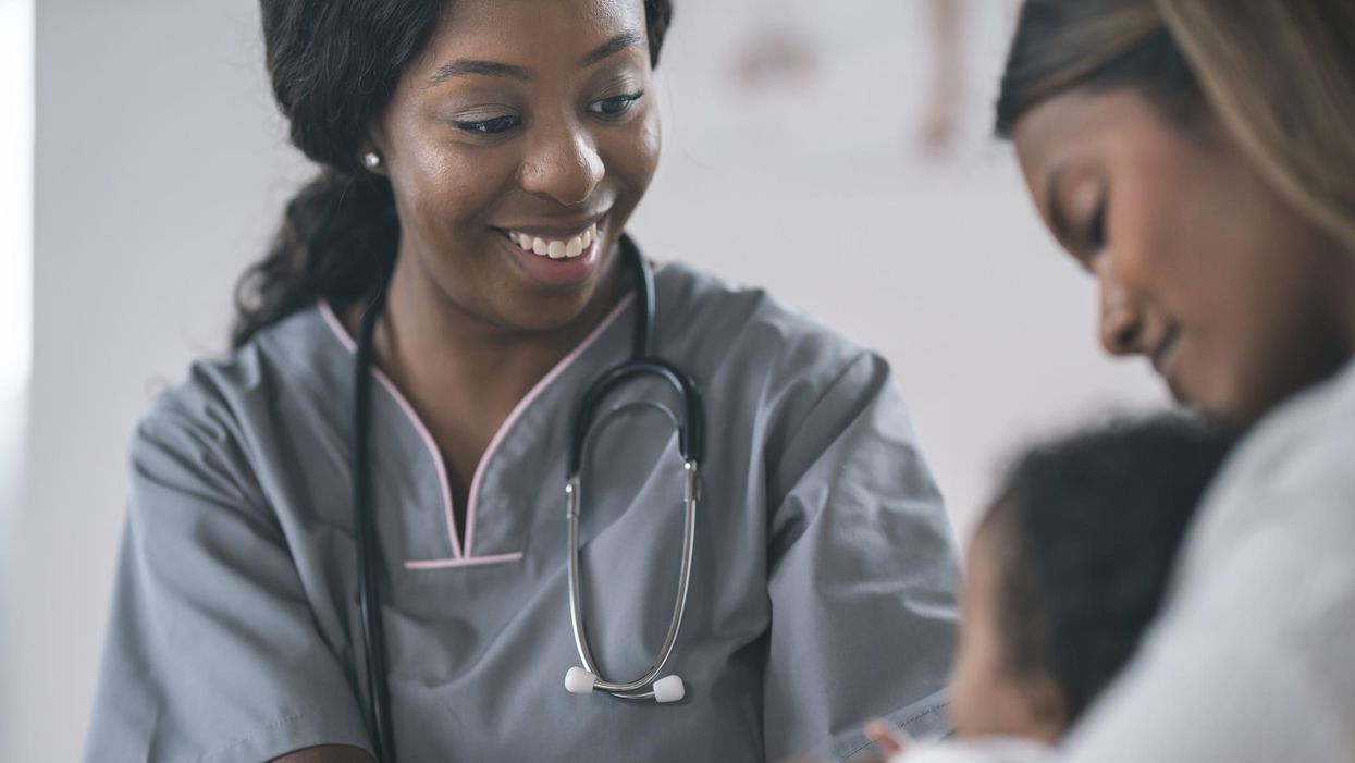 Nurse checking baby in wellness medical exam