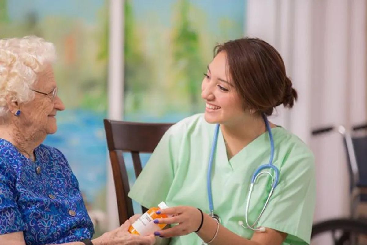 nurse helping older woman with medication