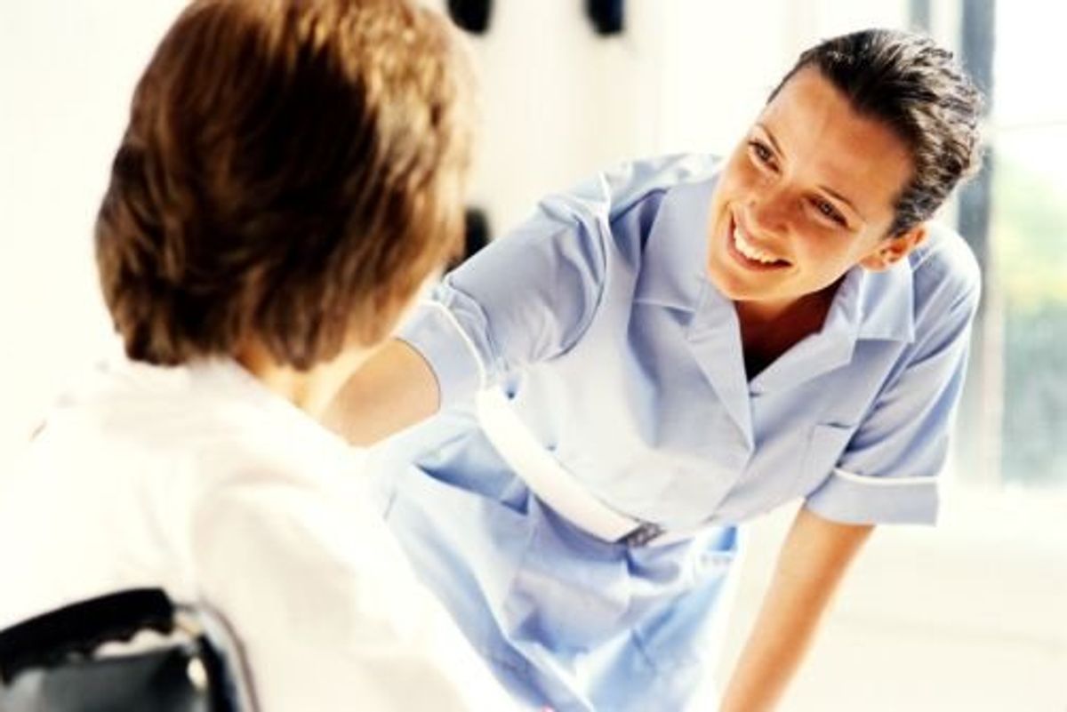 nurse helping patient in a wheelchair