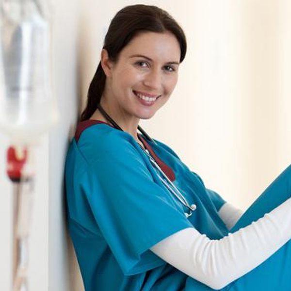 Nurse sitting with apple in hospital corridor