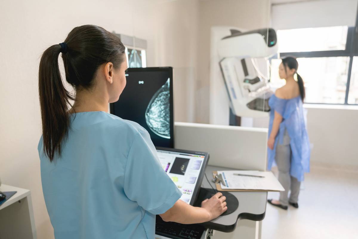 nurse taking a mammogram exam to an adult patient