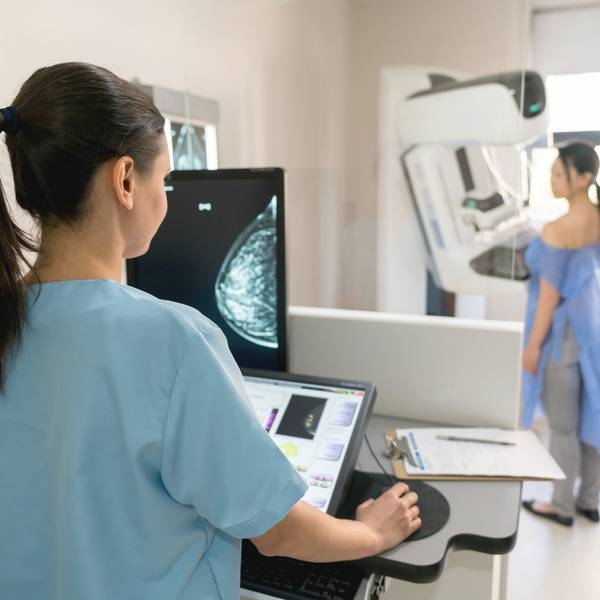 nurse taking a mammogram exam to an adult patient