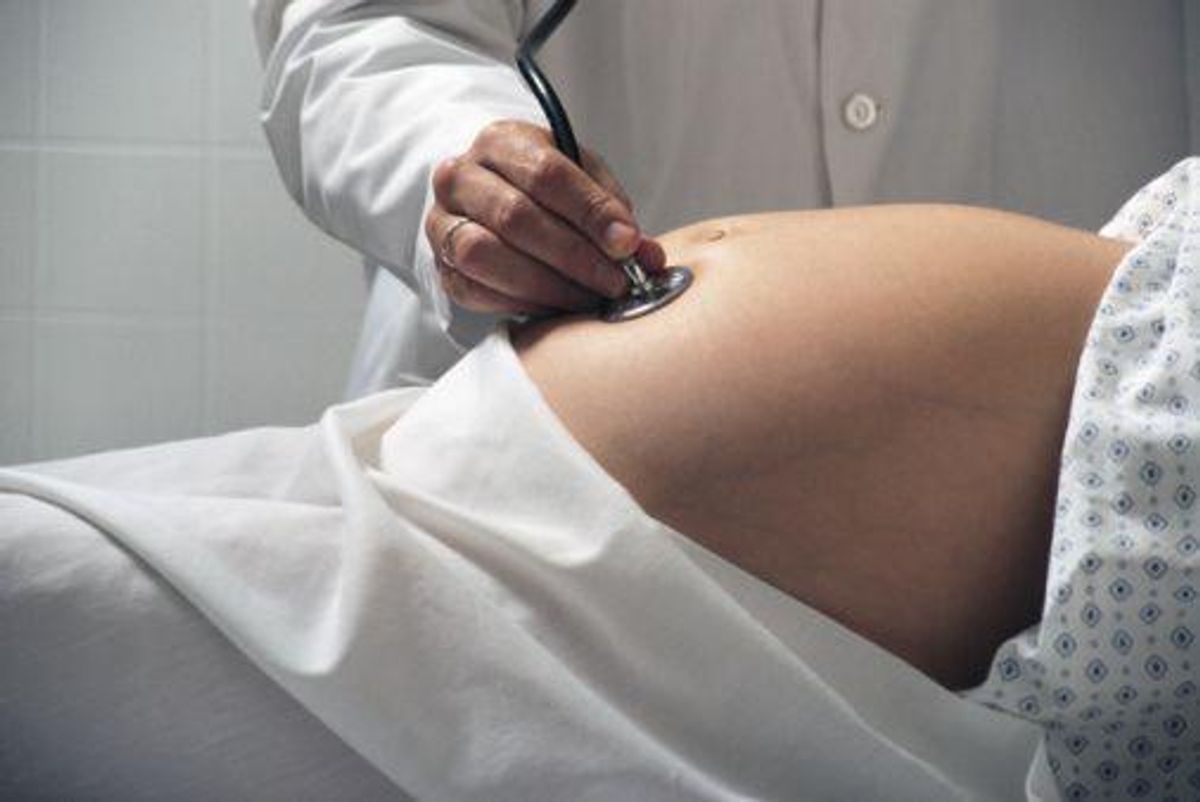 ob/gyn checking pregnant mom's stomach