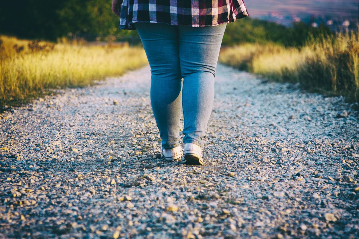 obese Young woman walking on country road