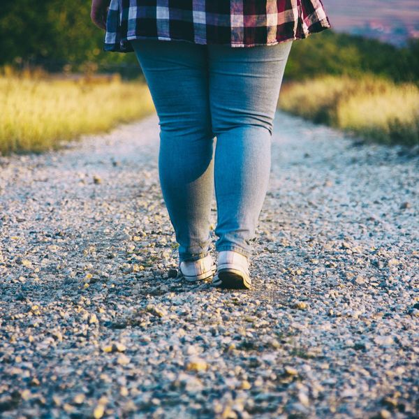 obese Young woman walking on country road