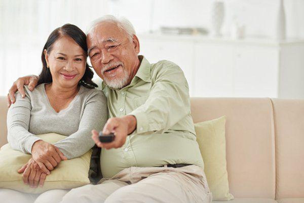 older couple watching tv on the couch