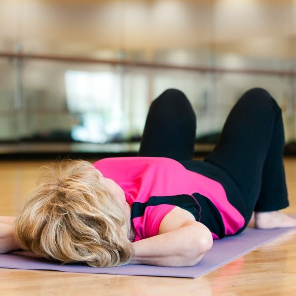 older woman doing exercises on a yoga mat