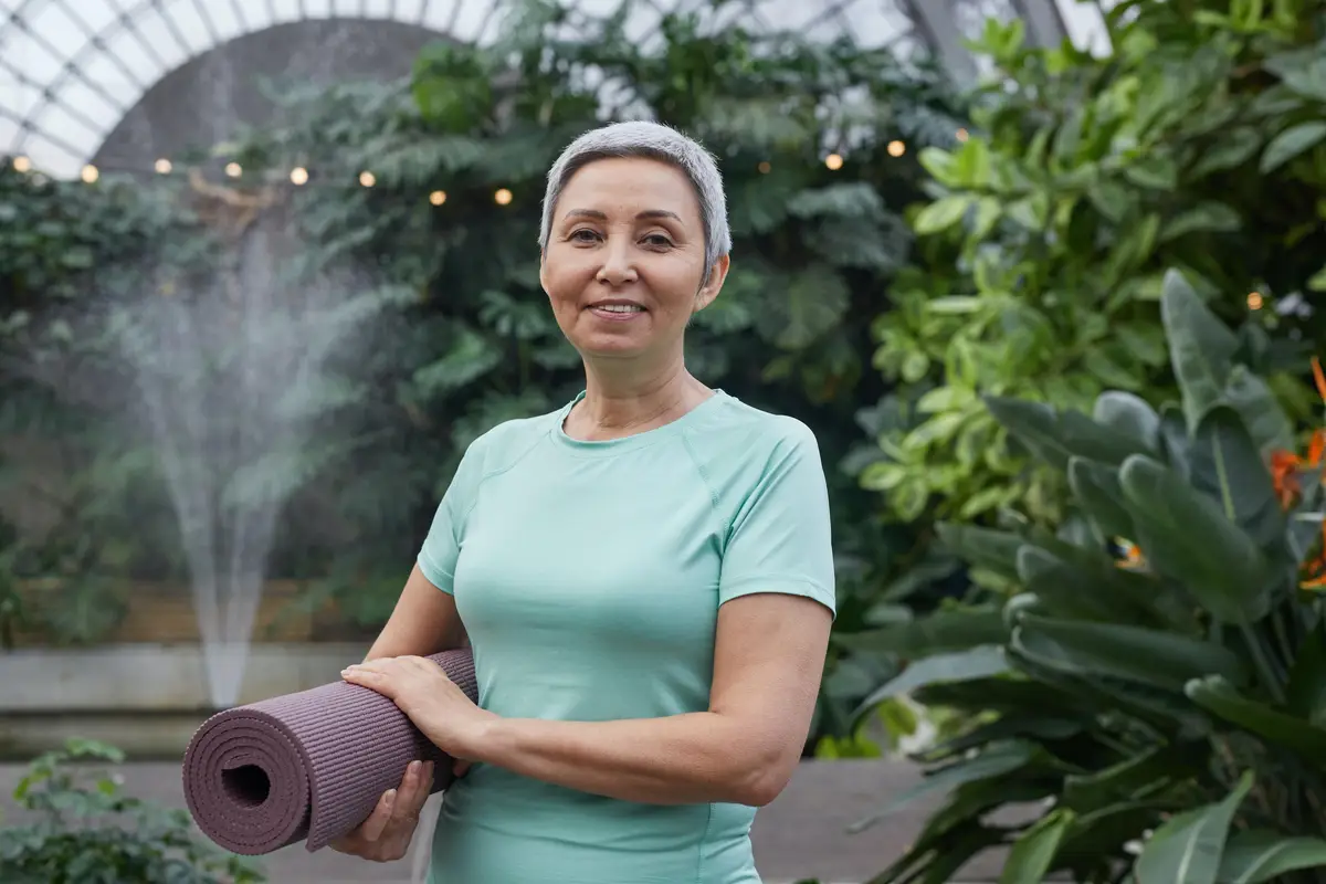 older woman holding a yoga mat