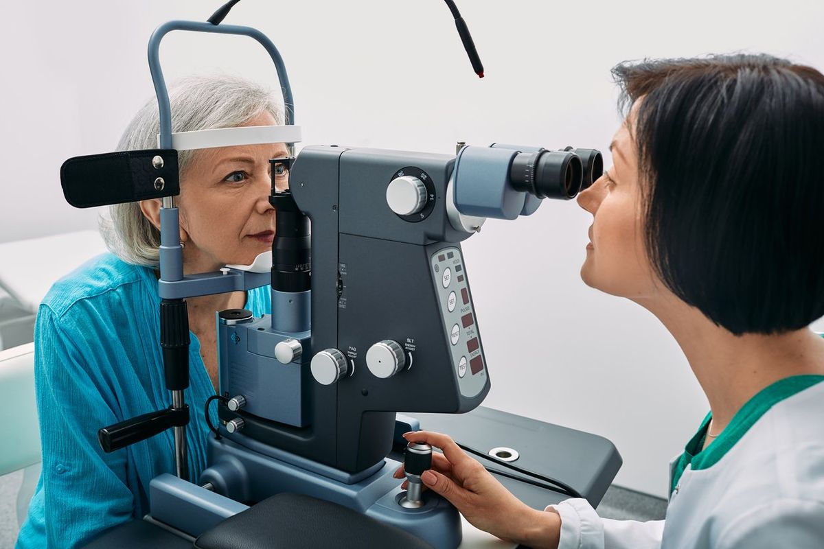 optometrist doing sight test to senior woman at modern ophthalmology clinic