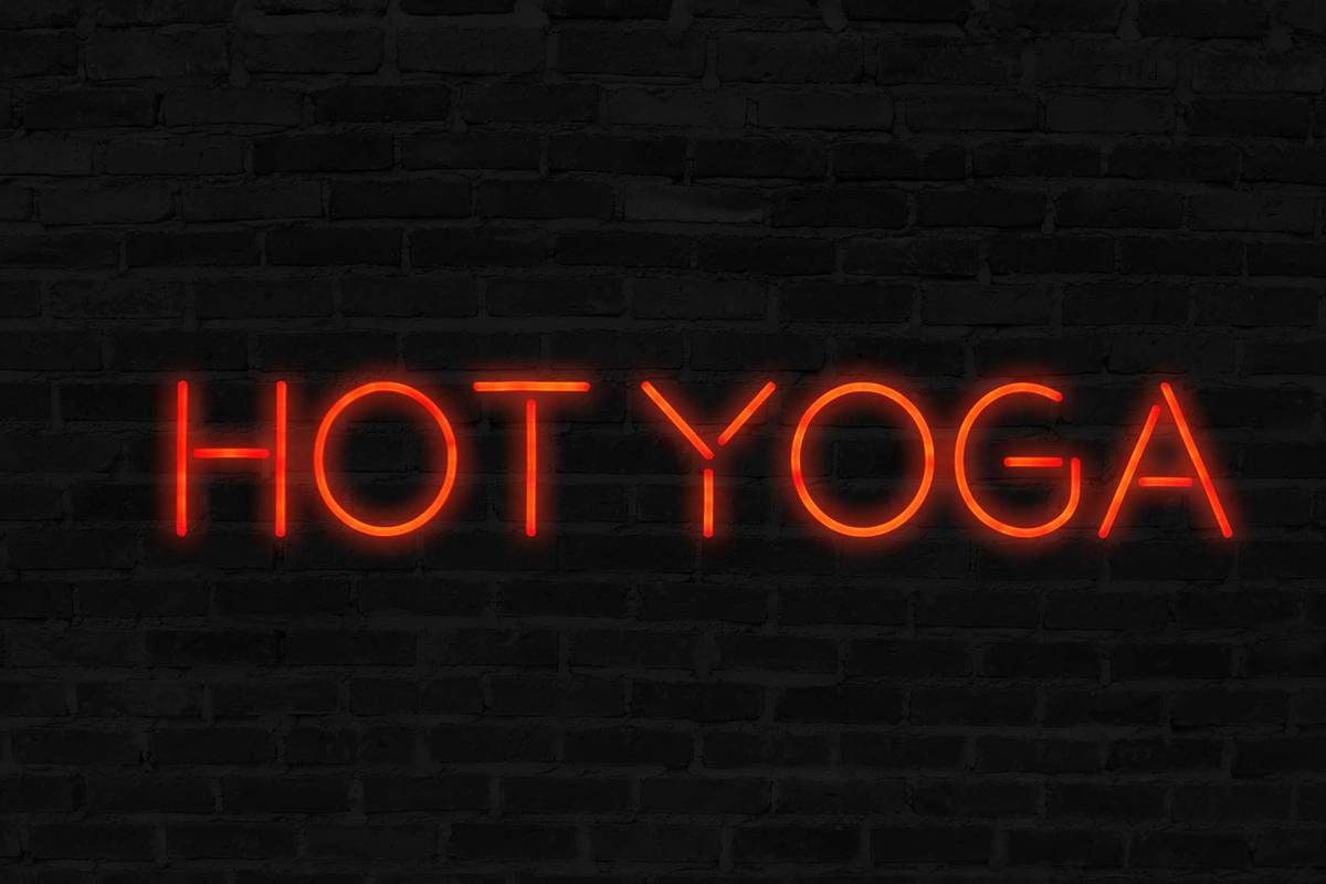 Orange Hot Yoga neon sign with brick wall