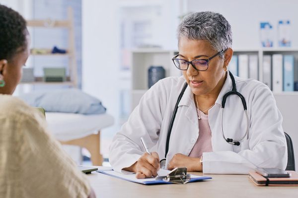patient and doctor writing in hospital for appointment,