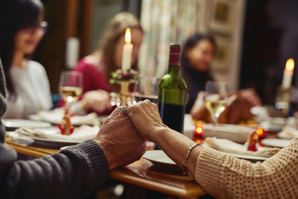 people holding hands in prayer before having a meal together