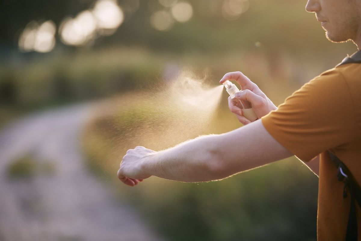 person applying nature mosquito repellent to their arm