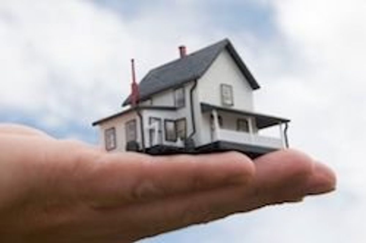 person holding a small house in their hand