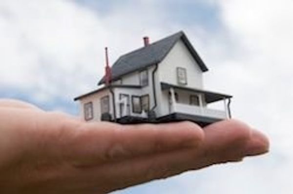 person holding a small house in their hand