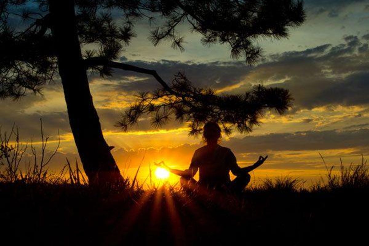 person meditating in a field