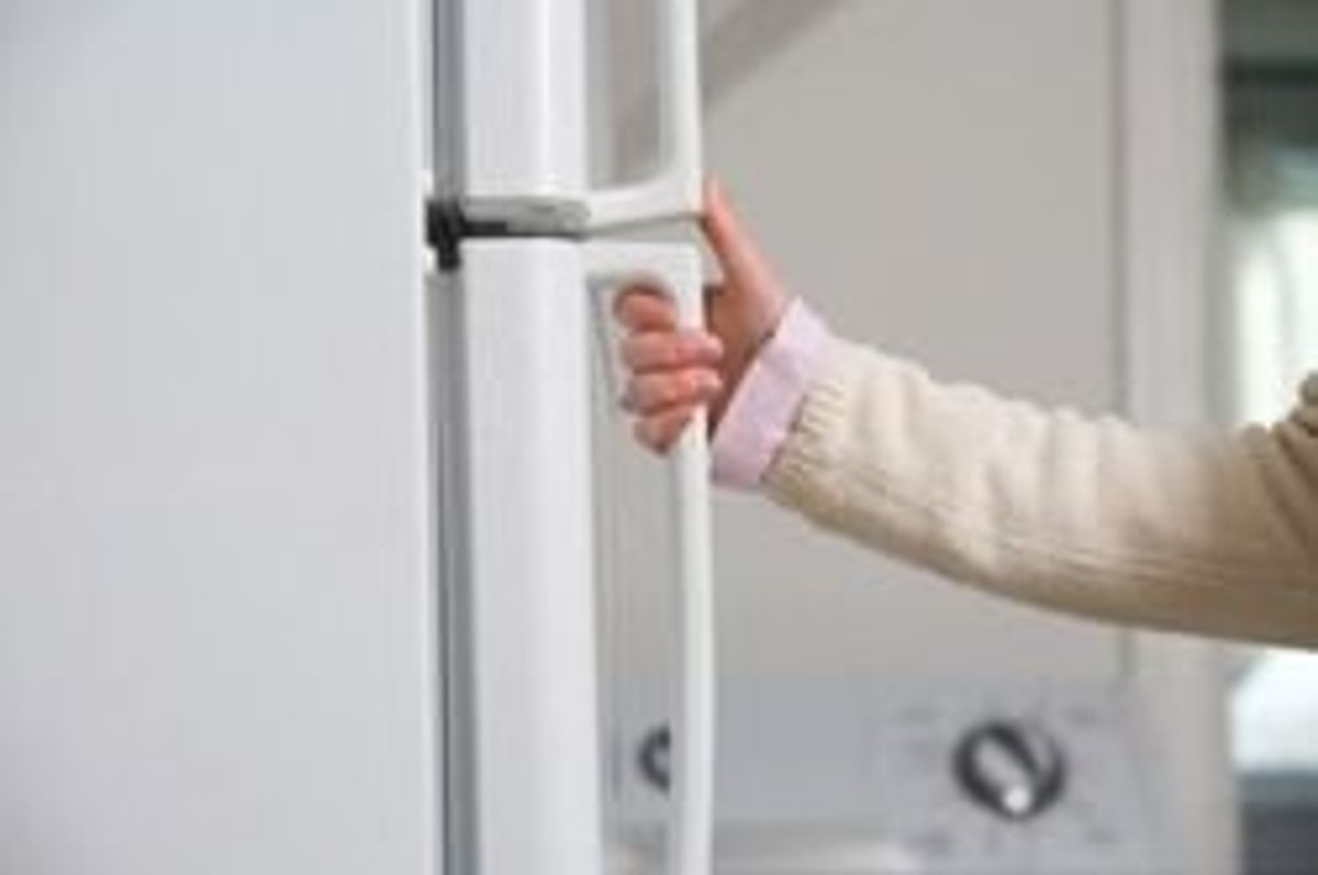person with their hand on the fridge