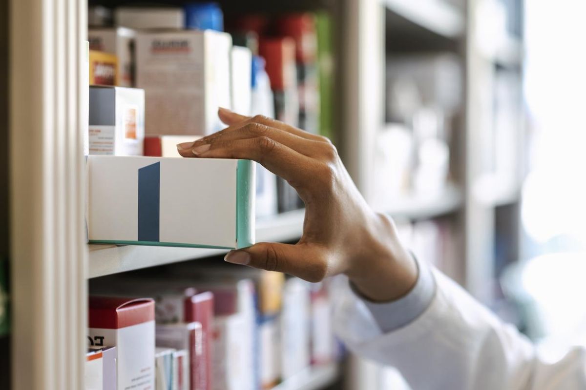 pharmacist hand holding medicine box in pharmacy drugstore