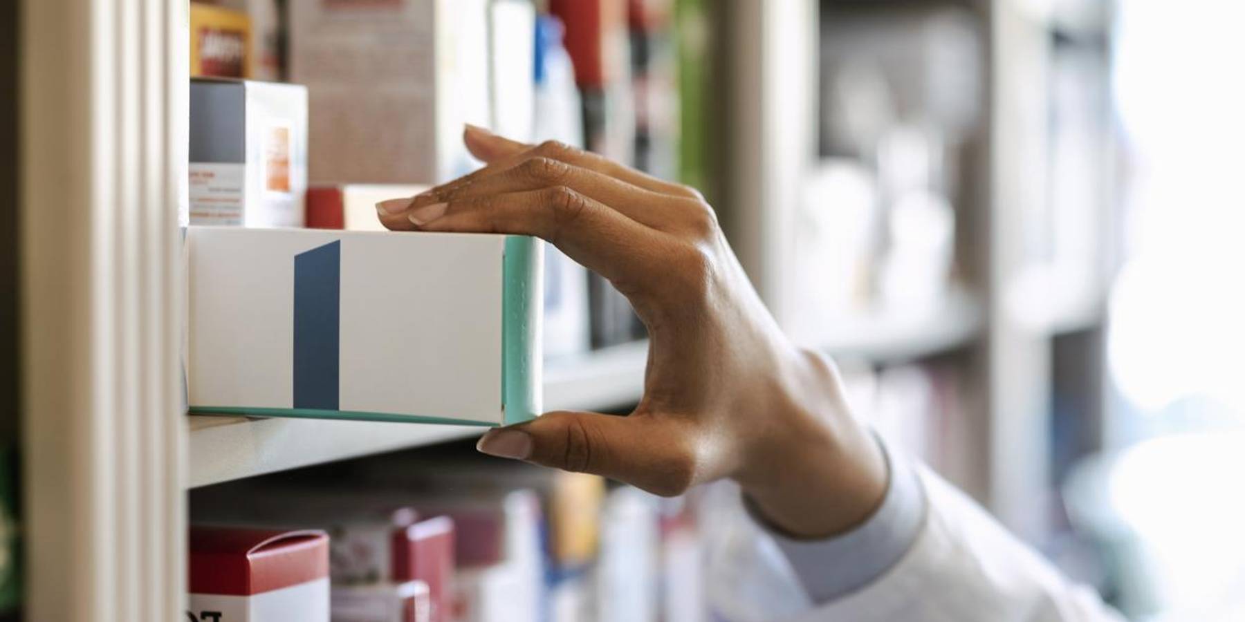 pharmacist hand holding medicine box in pharmacy drugstore