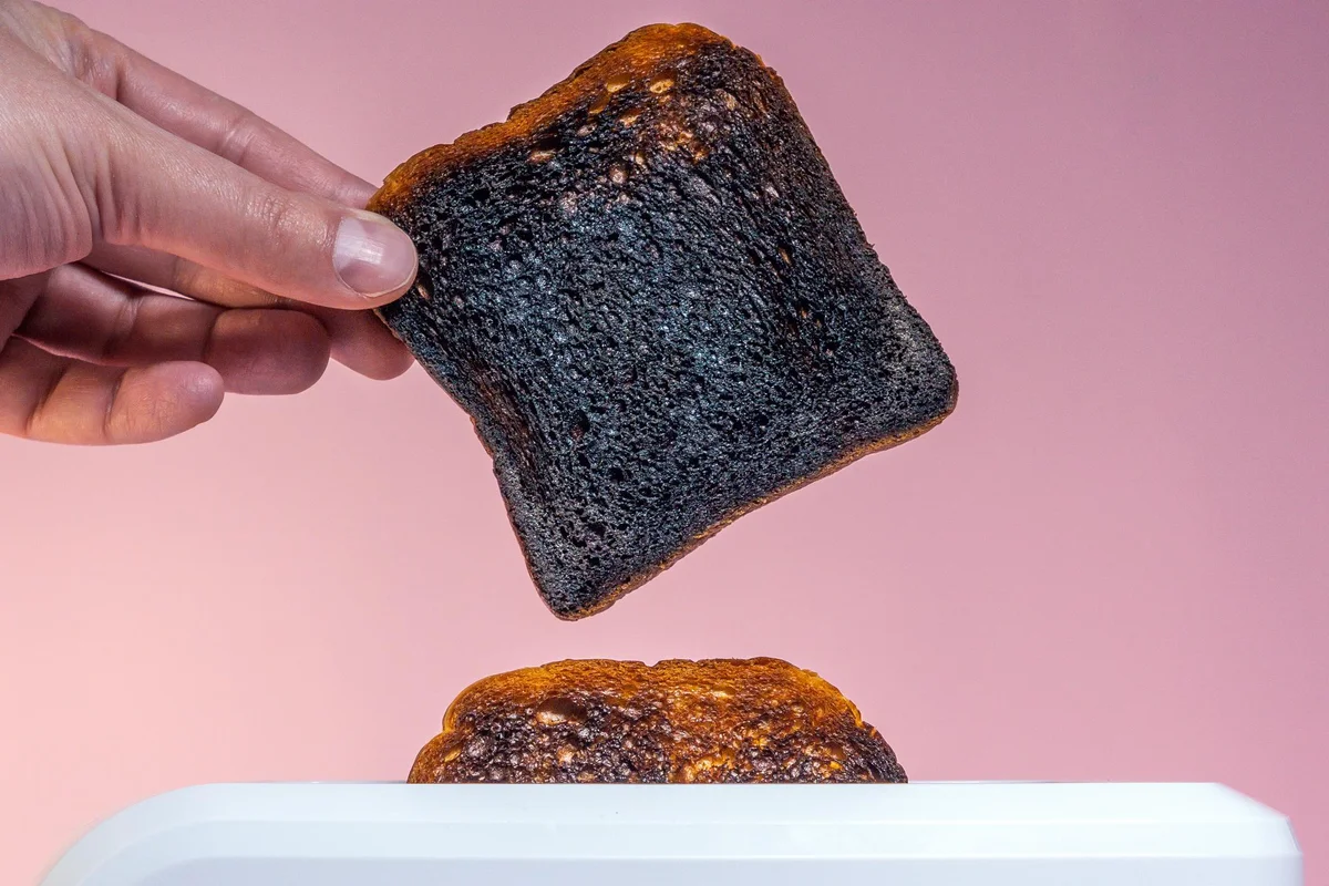 Pieces of burnt bread pop-up from breadtoaster.