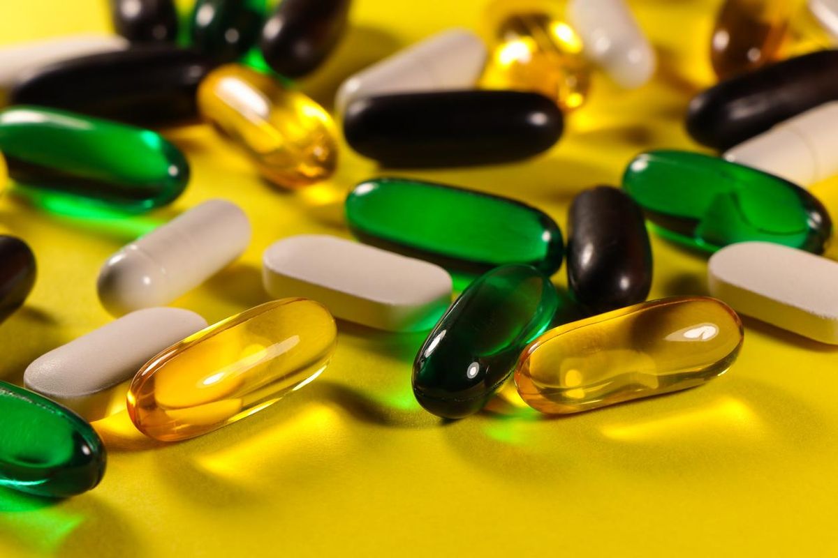 Pill And Capsule Variety On Bright Yellow Surface