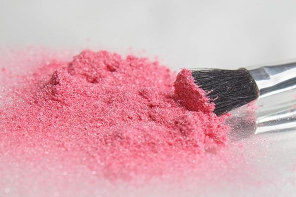 pink blush powder and a blush brush