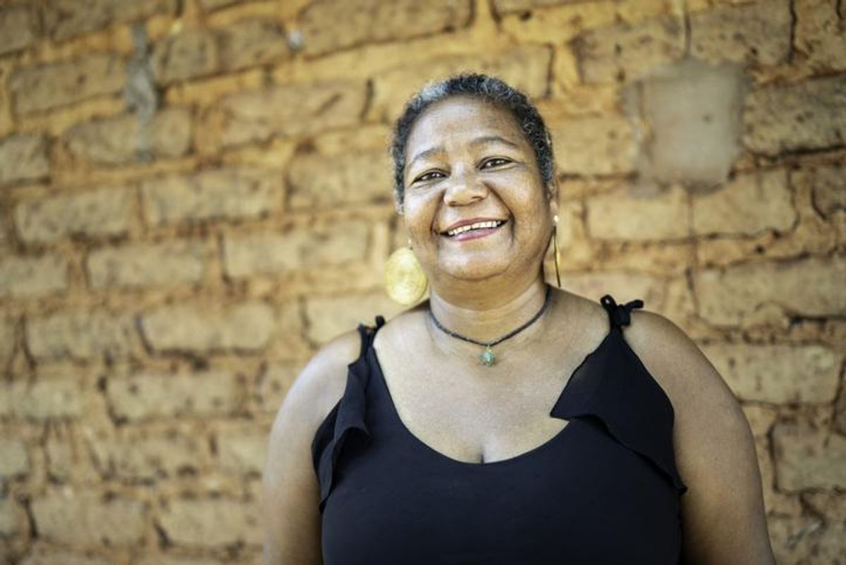Portrait of a mature woman in front of a wattle and daub house