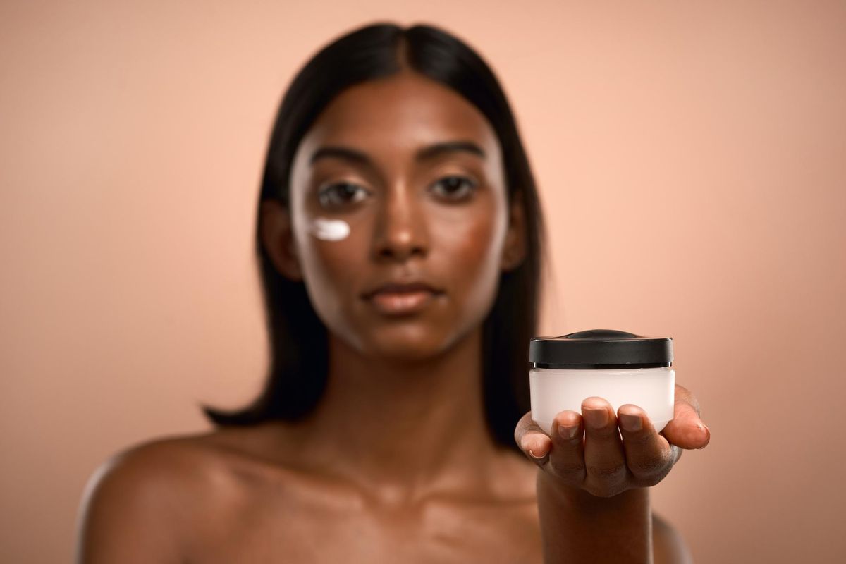 Portrait of an woman applying moisturiser