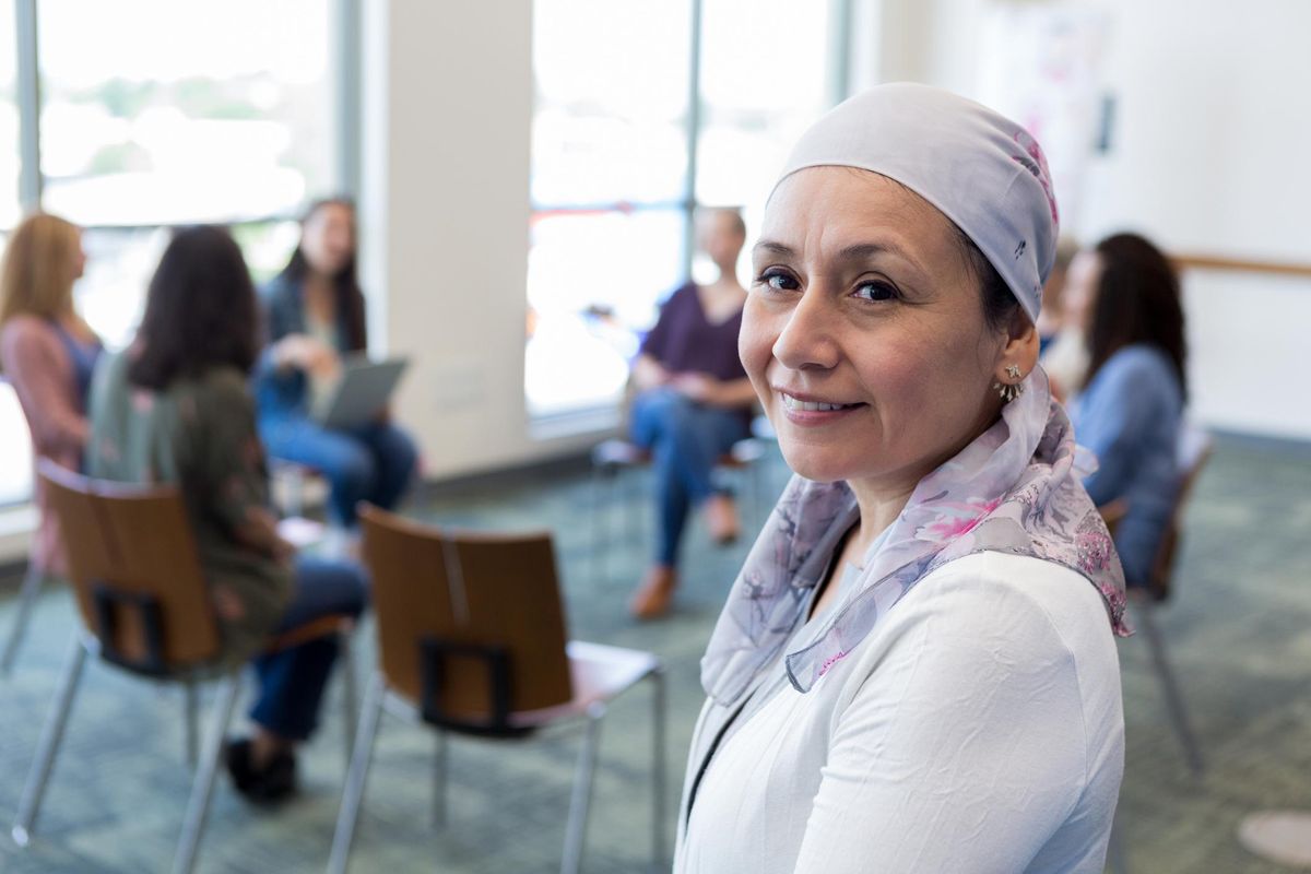 Portrait of cancer survivor with support group in background