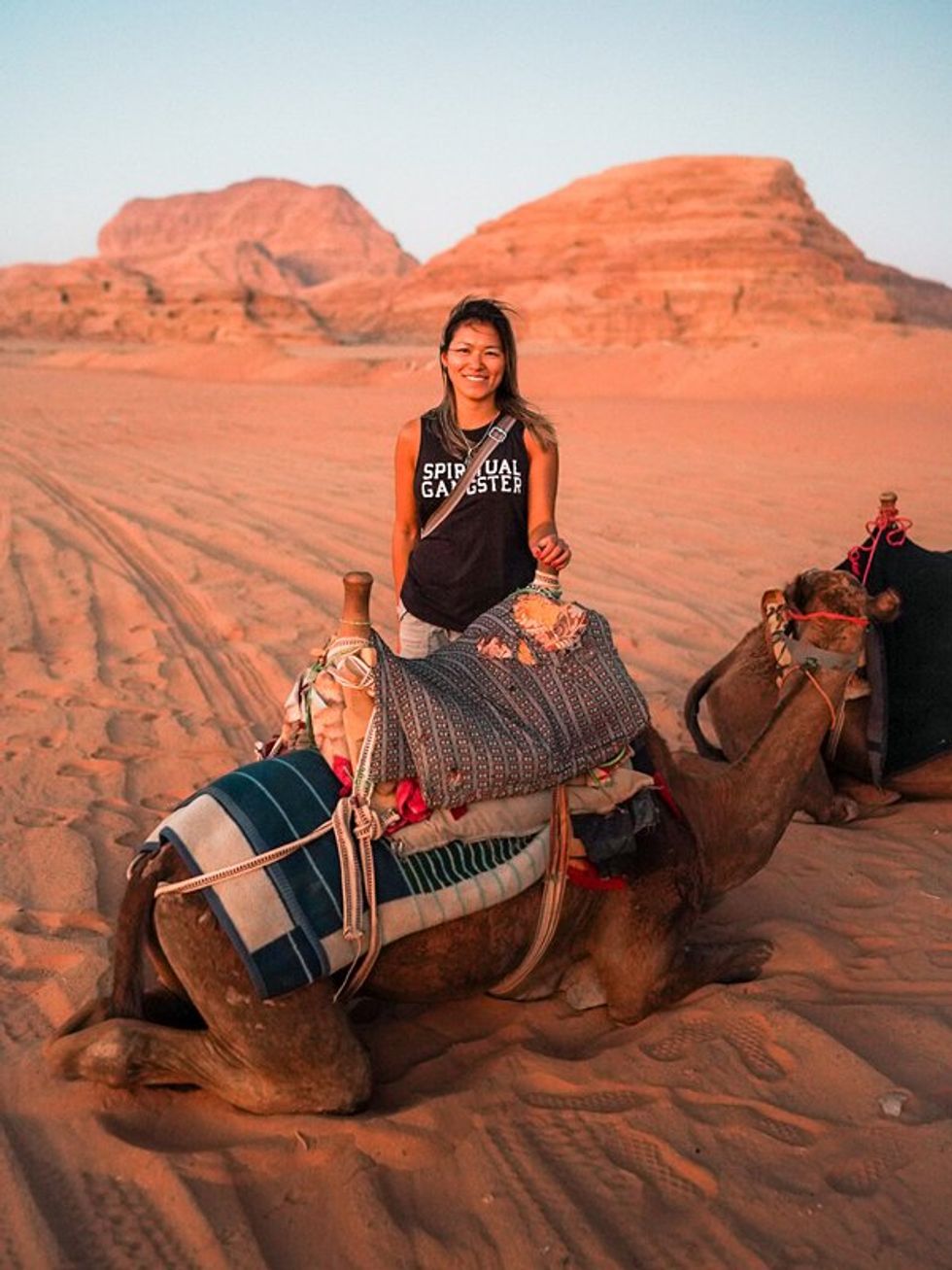 posing with a camel in the desert