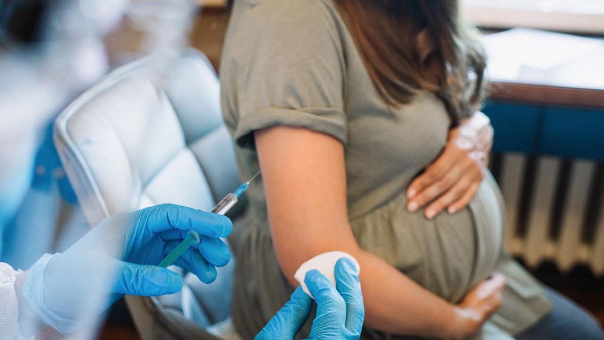 Pregnant woman getting vaccine at home. COVID-19 vaccination concept.