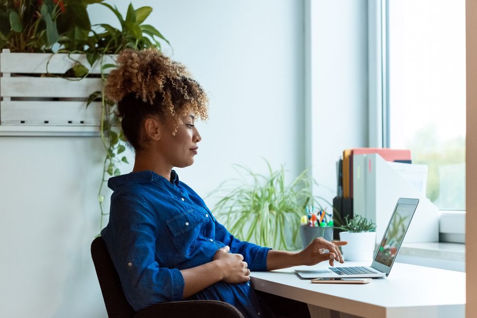 pregnant woman looking at a laptop