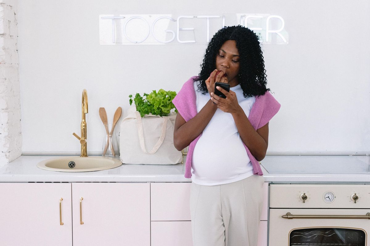 pregnant woman looking at her phone