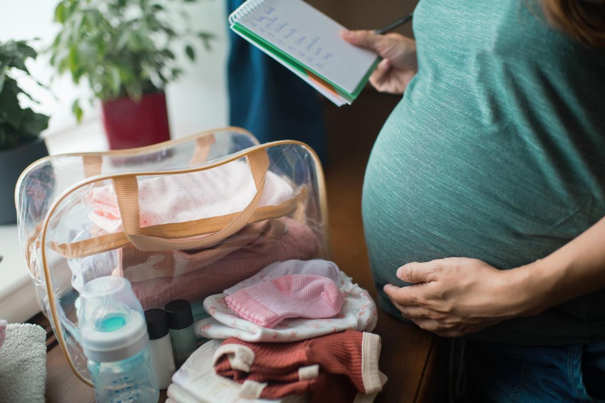 Pregnant woman preparing bag for the hospital for childbirth