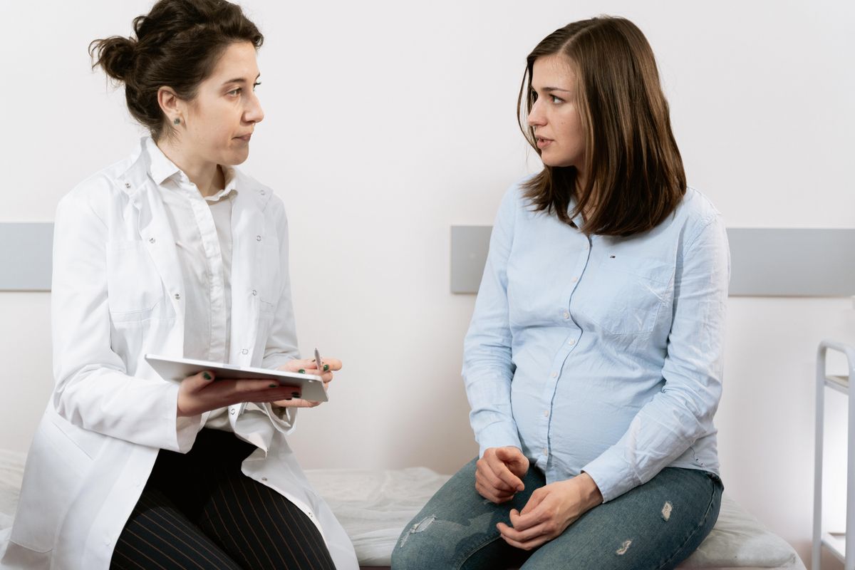 pregnant woman speaking with her doctor