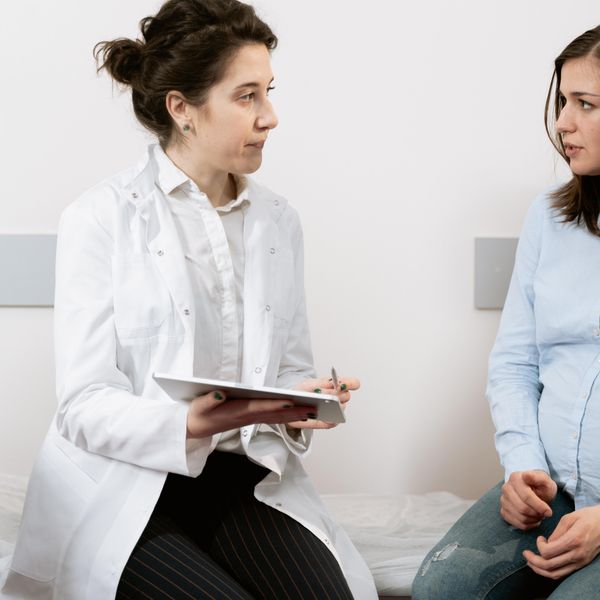 pregnant woman speaking with her doctor
