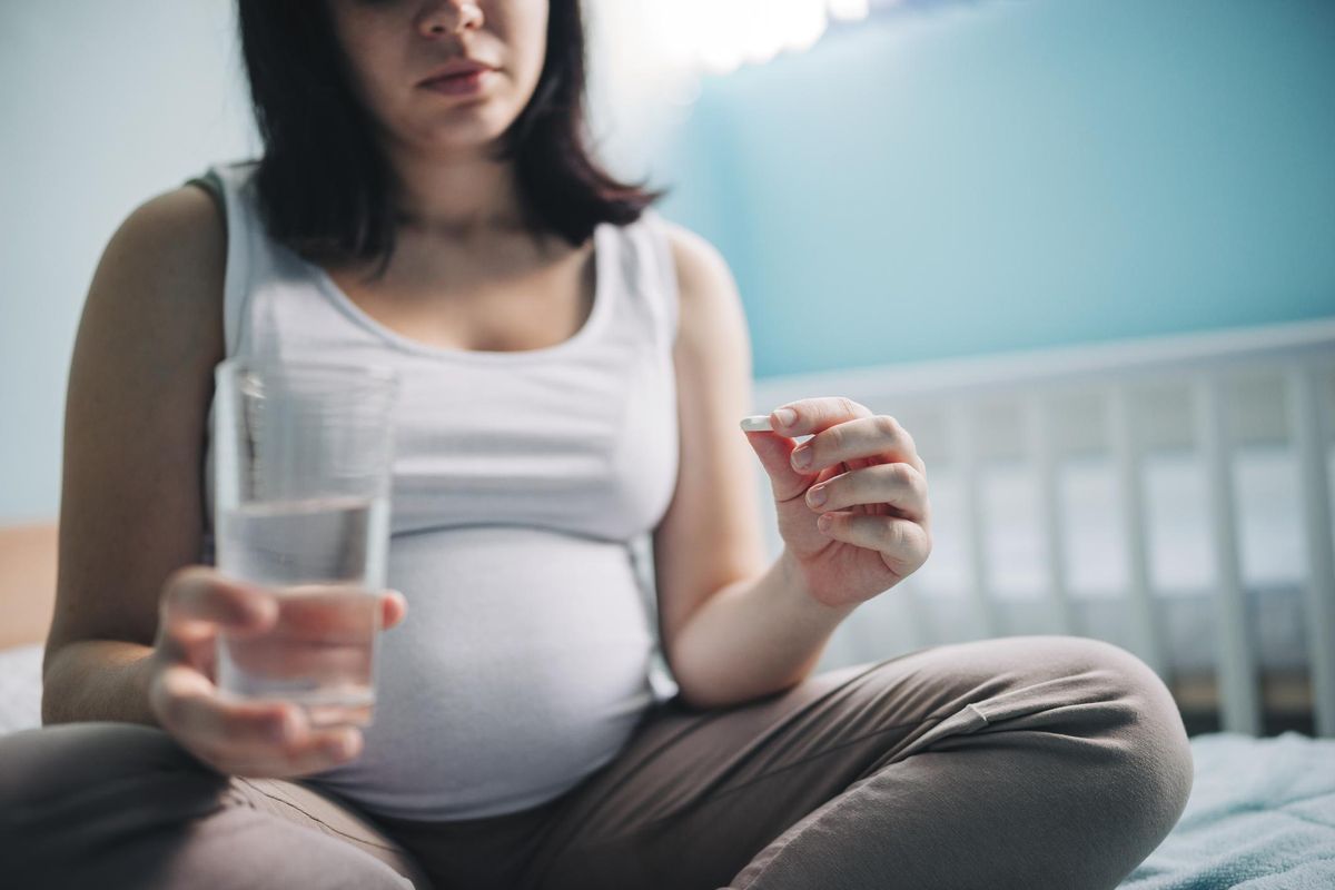 Pregnant woman taking pill