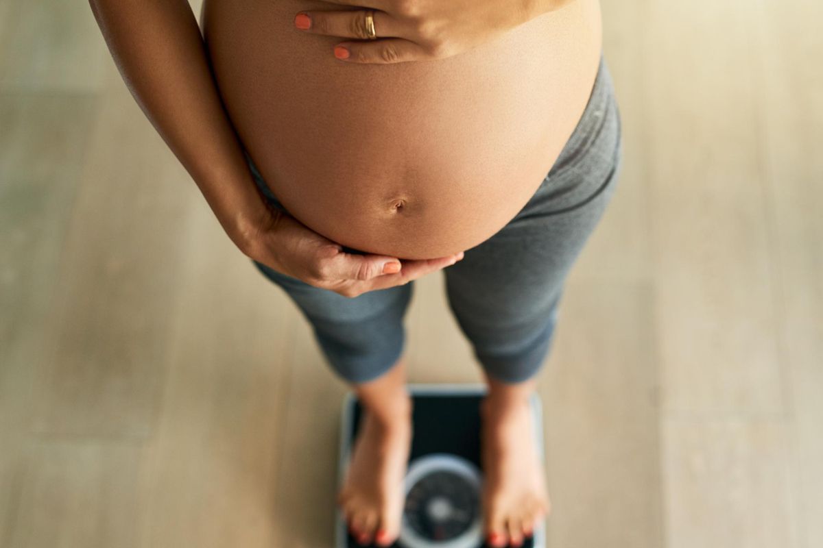 pregnant woman weighing herself on a scale