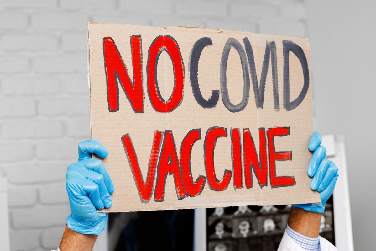 Protest banner with 'no COVID vaccine' text