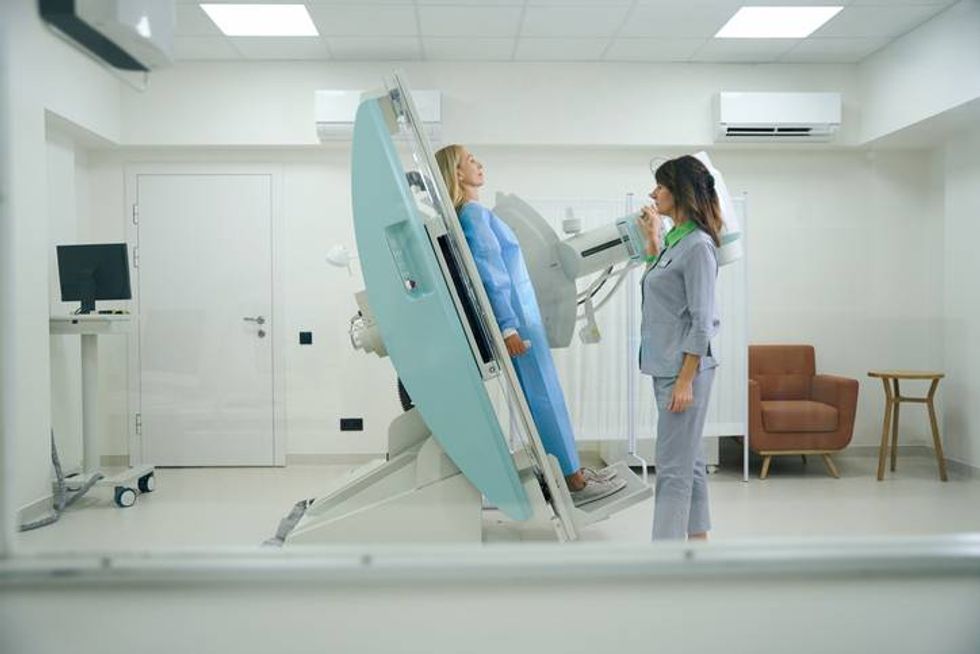 radiologic technologist preparing adult female for tilt table test