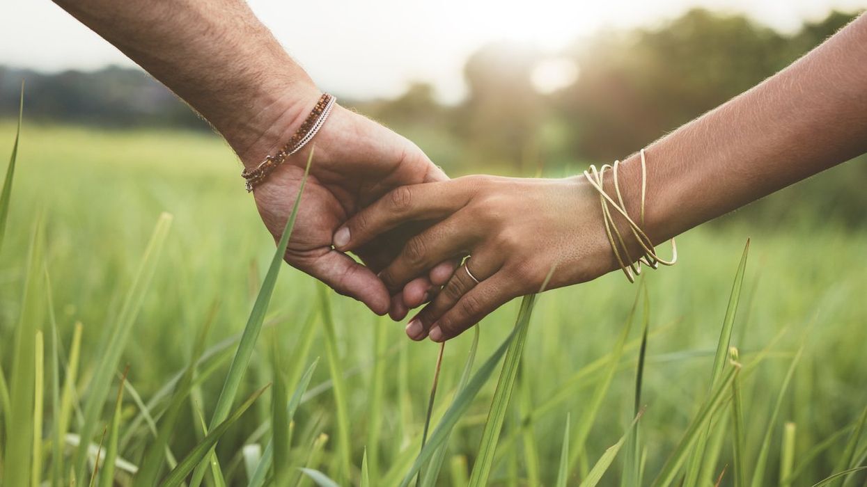 Romantic couple holding hands in a field
