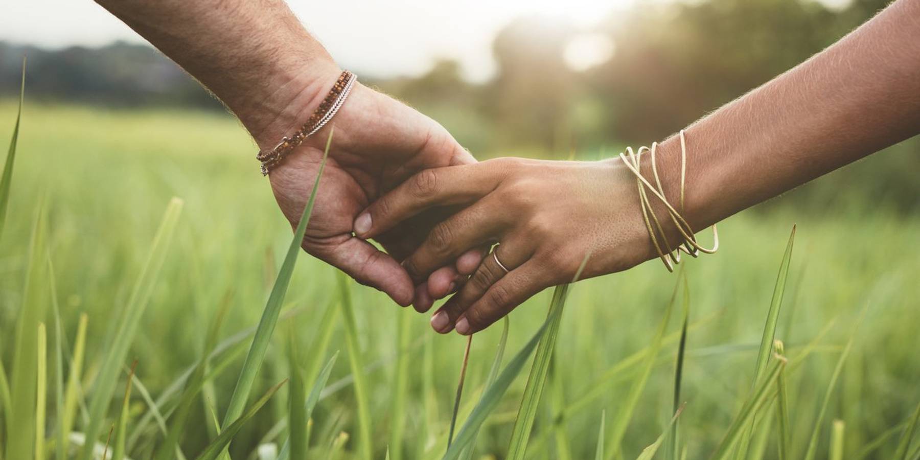 Romantic couple holding hands in a field