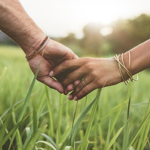 Romantic couple holding hands in a field