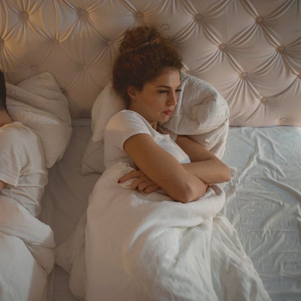 sad couple laying in bed