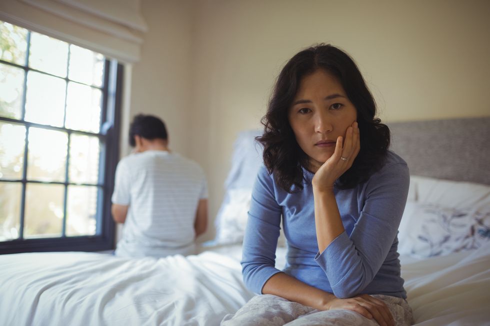 sad woman sitting on her bed