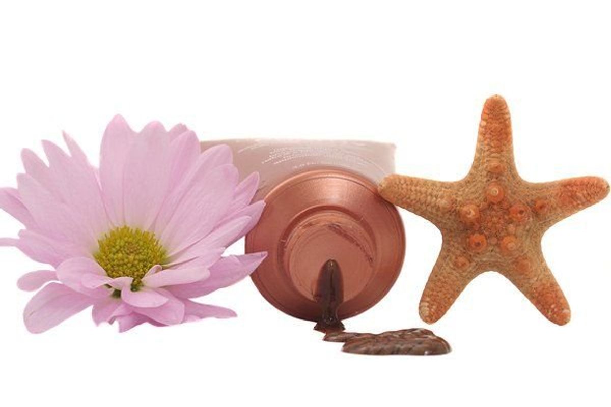 self-tanning lotion next to a flower and a starfish