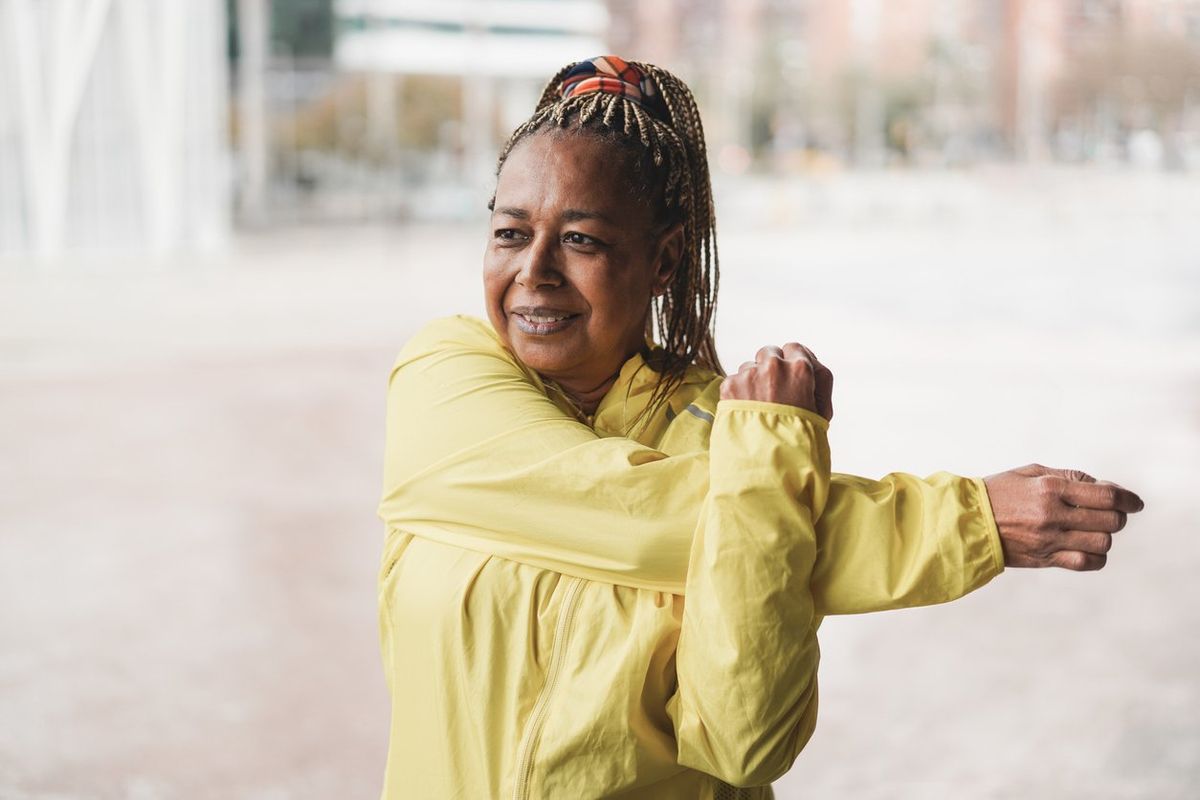 Senior african woman stretching during workout routine